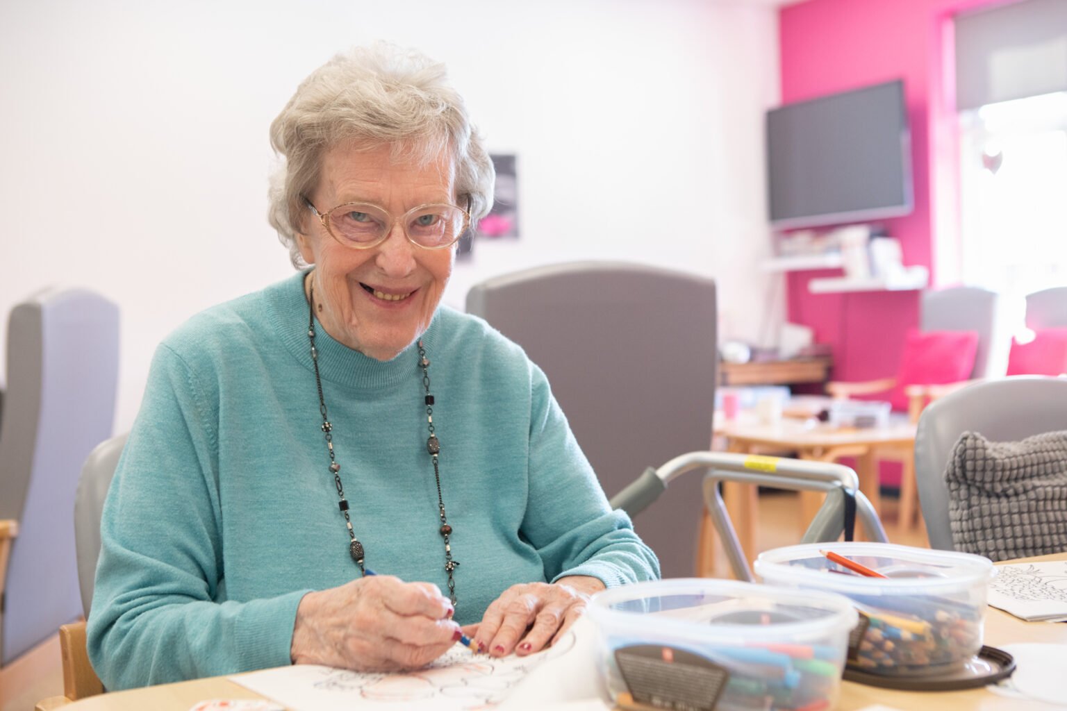 An older woman drawing at a desk