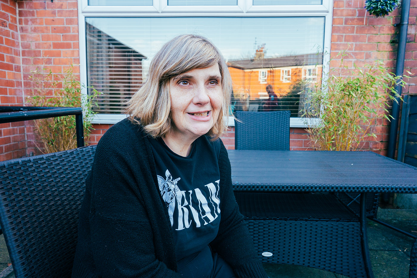 A lady sitting outside in the garden on a sunny day