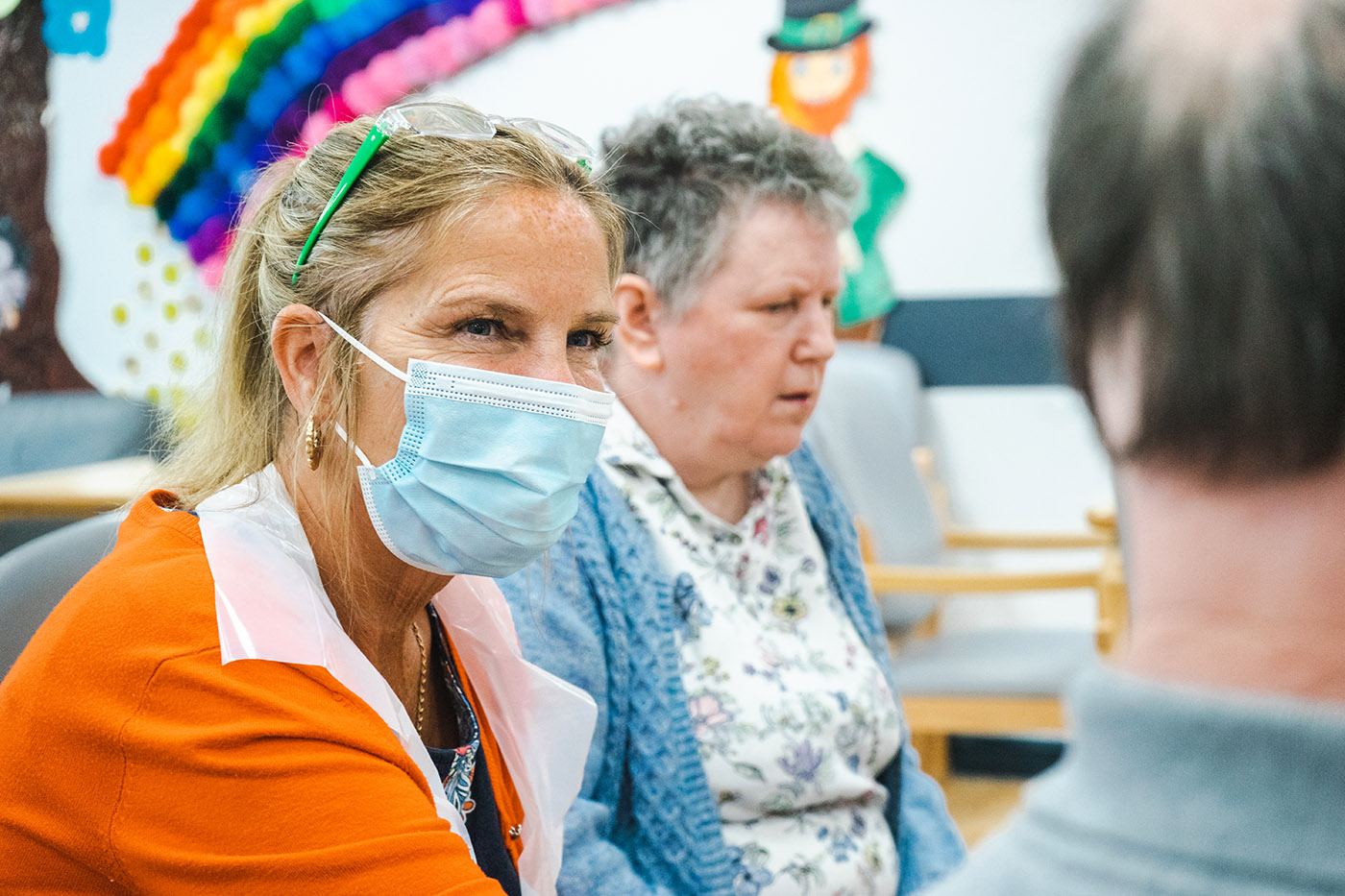 carer sat with some elderly people at a group activity event