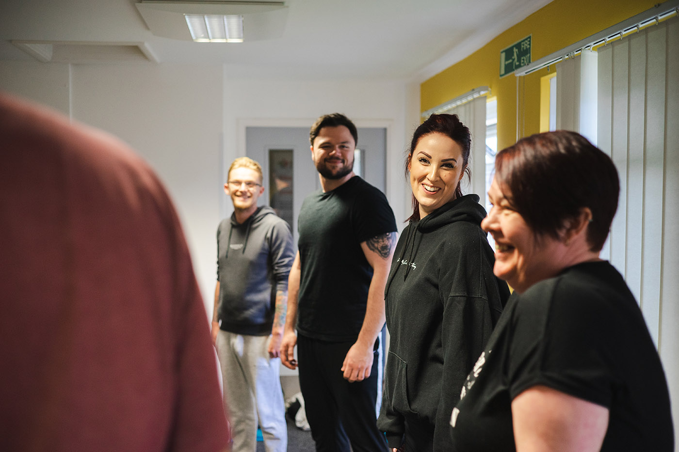 Staff standing in a circle doing a group activity and laughing together