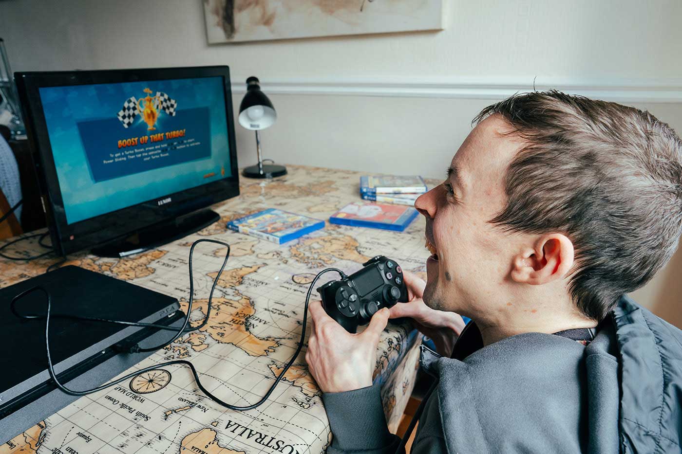 young man playing a computer game and laughing